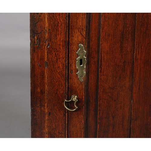 188 - AN EARLY 19TH CENTURY OAK HANGING CORNER CUPBOARD, having a moulded cornice above a single door with... 