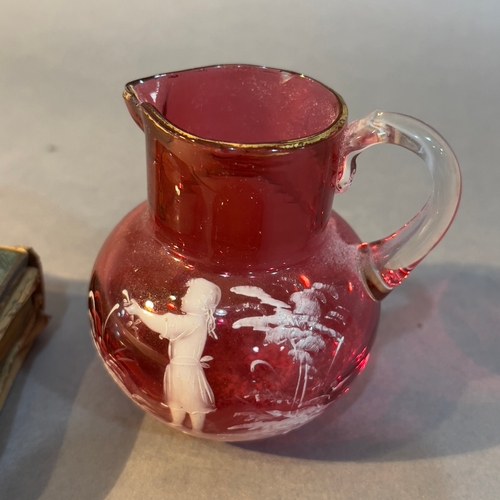 360 - A miniature cranberry jug with Mary Gregory style enamel to the side, a duck egg blue enamel and lea... 