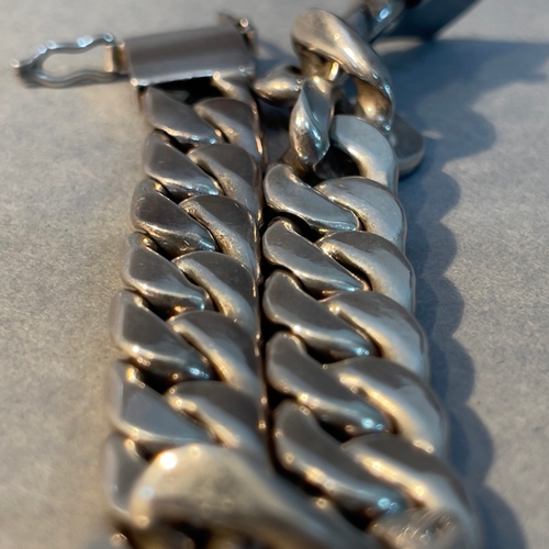 386 - A curb link bracelet in silver, approximate weight 59g