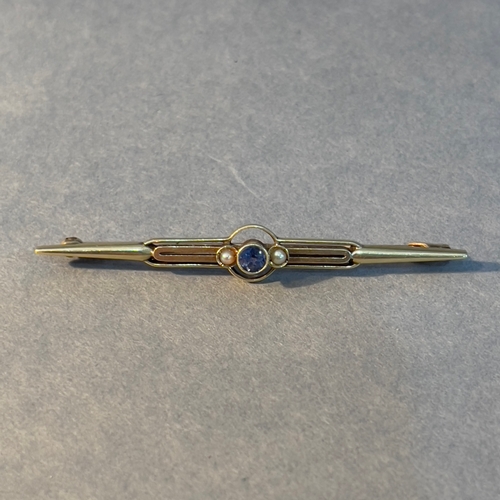 399 - An Art Deco sapphire and seed pearl bar brooch in 15ct gold, collet set to the centre with a circula... 