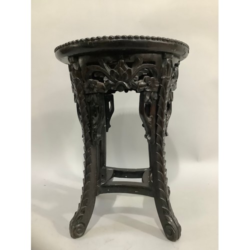 404 - A carved Chinese hardwood jardiniere, the top inset with marble, 47cm high