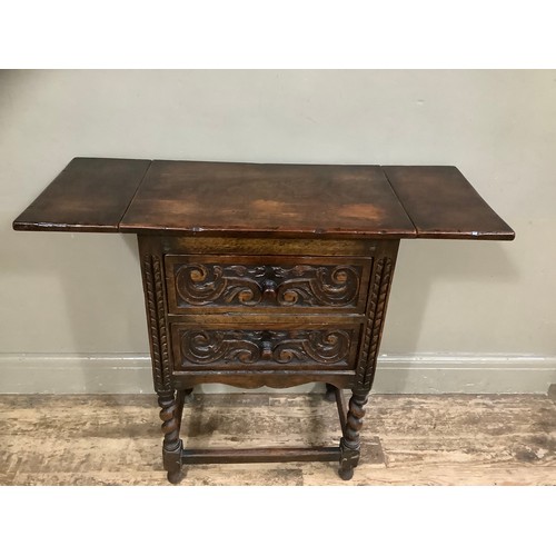 407 - An early 20th century oak drop leaf two drawer side table on barley twist legs having heavily carved... 