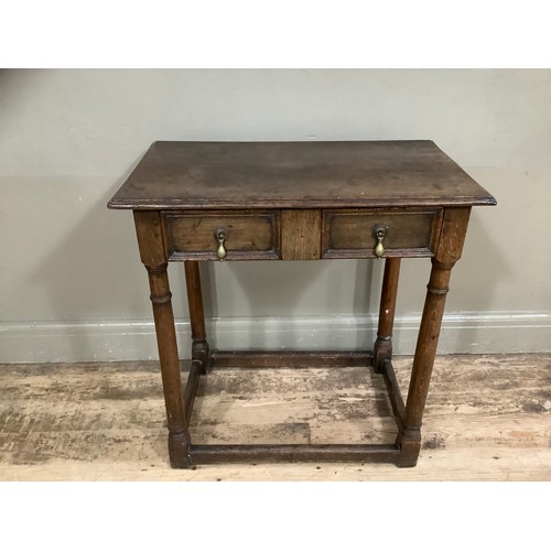 417 - An early 19th century oak side table with rounded legs on stretcher with two drawers, 72cm wide