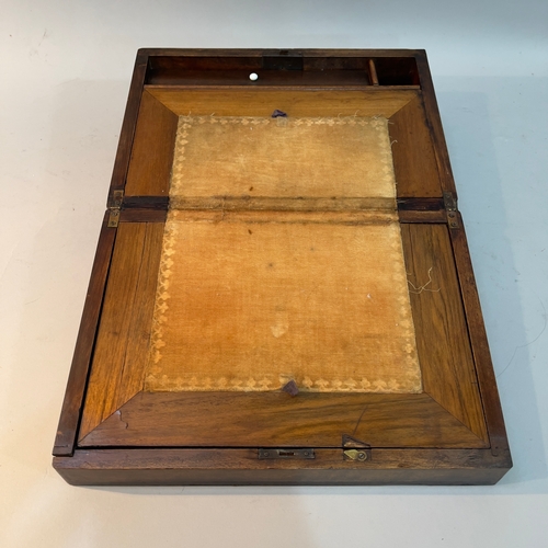 215 - A 19th century walnut writing slope the lid inlaid having a mother of pearl escutcheon, with a fitte... 