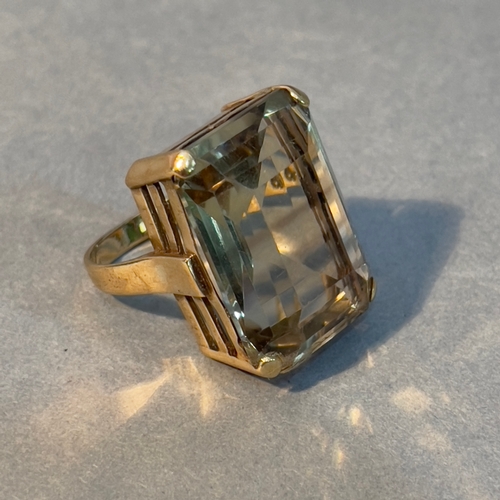 380 - A smoky quartz dress ring in 9ct gold c1964, the large step cut stone claw set and flanked by plain ... 