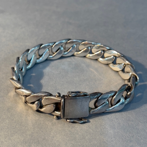 386 - A curb link bracelet in silver, approximate weight 59g