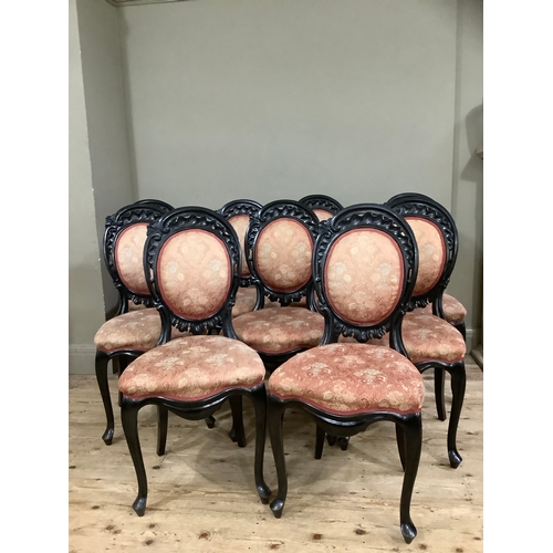 438 - A set of nine 19th century ebonised dining chairs having carved and pierced rocaille cresting above ... 