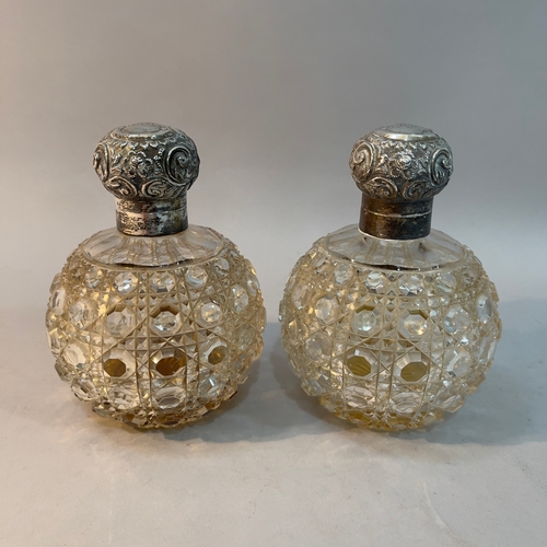 50 - A pair of Edward VII silver lidded cut glass cologne bottles of spherical outline, hobnail cut and e... 