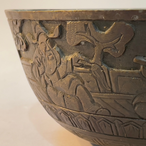 80 - A Chinese bronze ritual or singing bowl, the exterior engraved in relief with figures in a garden, h... 