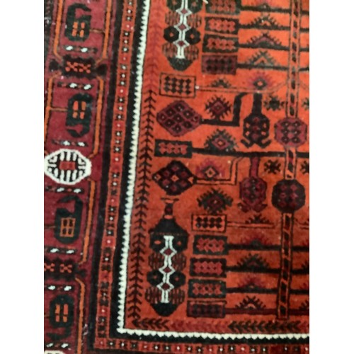 459 - An Afghan rug, the burnt orange ground filled with rows of stylised plan forms, within a wine, burnt... 