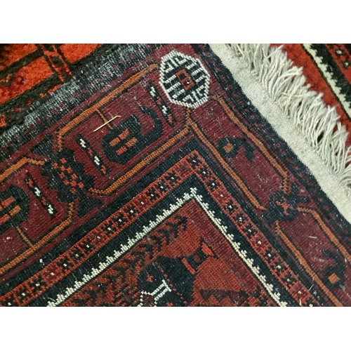 459 - An Afghan rug, the burnt orange ground filled with rows of stylised plan forms, within a wine, burnt... 