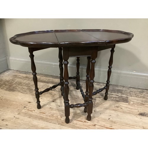 455 - A mahogany drop leaf gateleg table with dished pie crust top