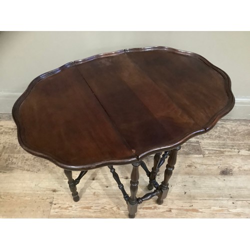 455 - A mahogany drop leaf gateleg table with dished pie crust top