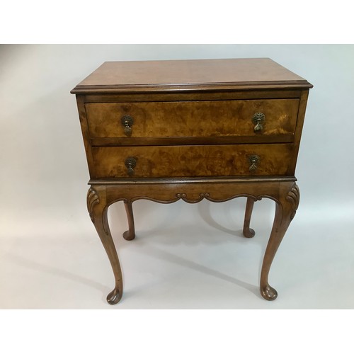 432 - A reproduction figured walnut two drawer side table on cabriole legs, 63cm wide