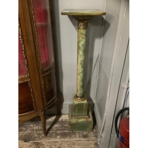 424 - An onyx and gilt metal torchere with square top above column on plinth base, 27cm wide x 107cm high