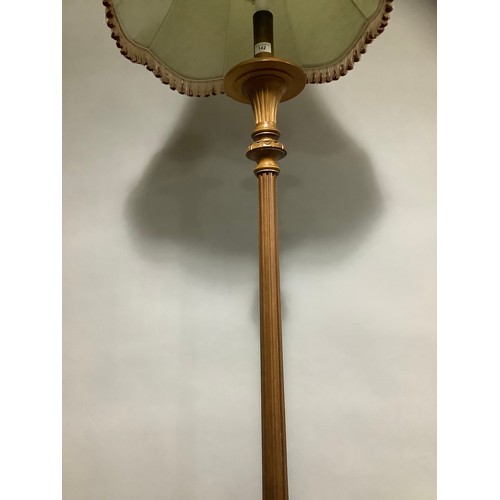 142 - A carved beech standing lamp with shade