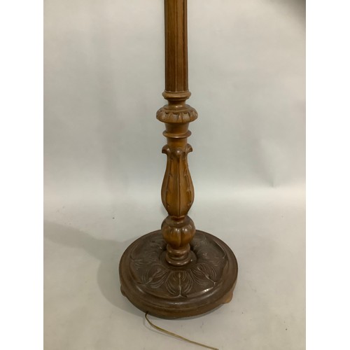 142 - A carved beech standing lamp with shade