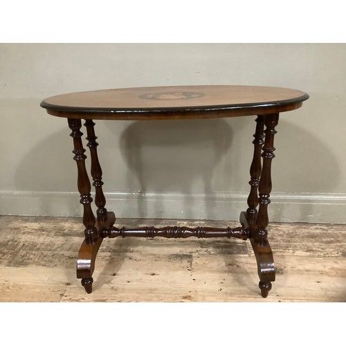 443 - A Victorian mahogany and walnut inlaid oval  window table the centre inlaid with flowers held in an ... 