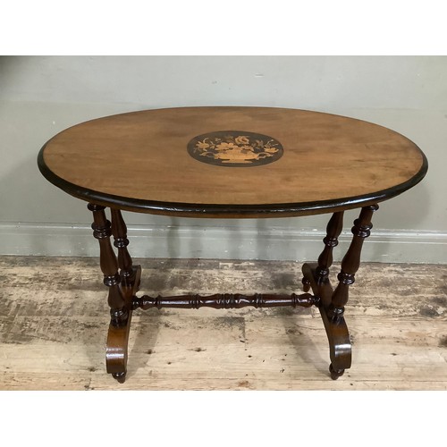 443 - A Victorian mahogany and walnut inlaid oval  window table the centre inlaid with flowers held in an ... 