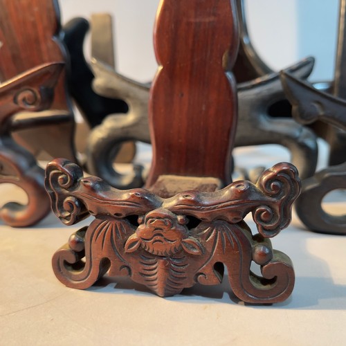 243 - Six Chinese wooden plate stands of pierced, carved and plain design, sizes from 14cm to 34cm high