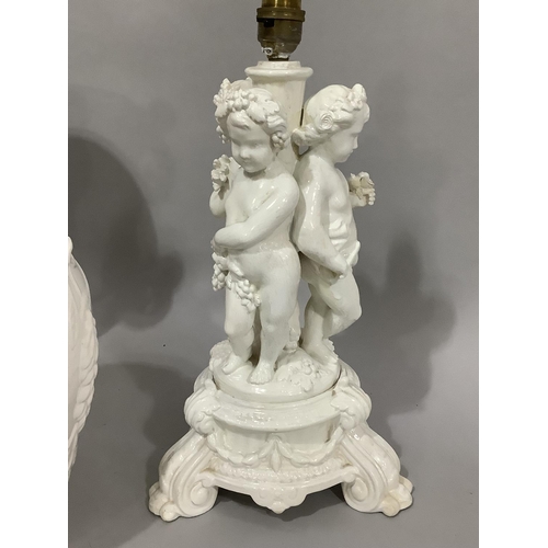 156 - A white pottery table lamp modelled as three cherubs on a fluted and swagged circular base together ... 