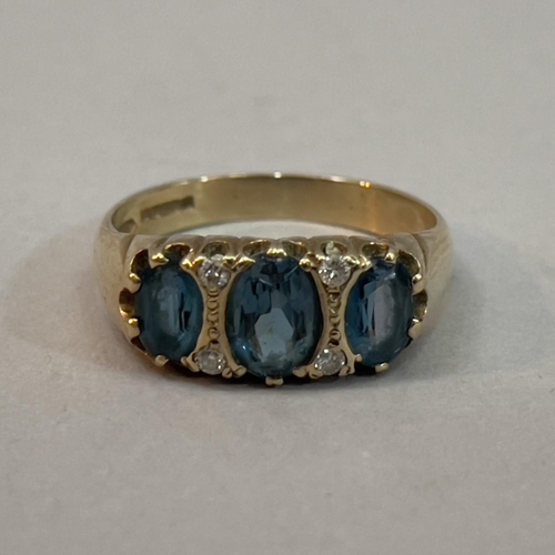 216 - A blue topaz and dress ring in 9 ct. gold by Michael l’Anson. The graduated oval facetted blue topaz... 