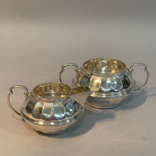 161 - A George V silver sugar bowl and cream jug pair by Ogdens of Harrogate and London, indented of circu... 