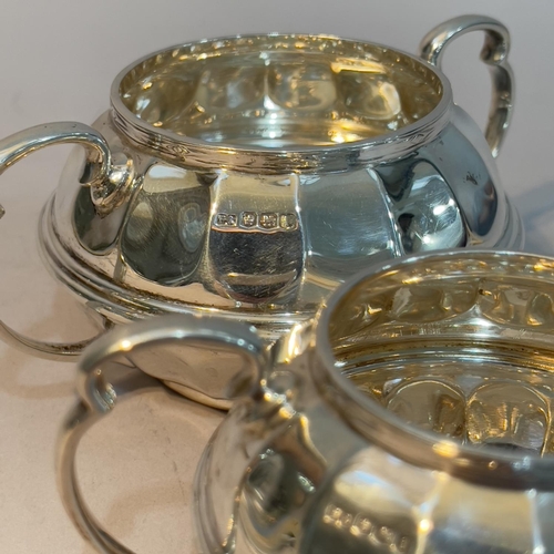 161 - A George V silver sugar bowl and cream jug pair by Ogdens of Harrogate and London, indented of circu... 