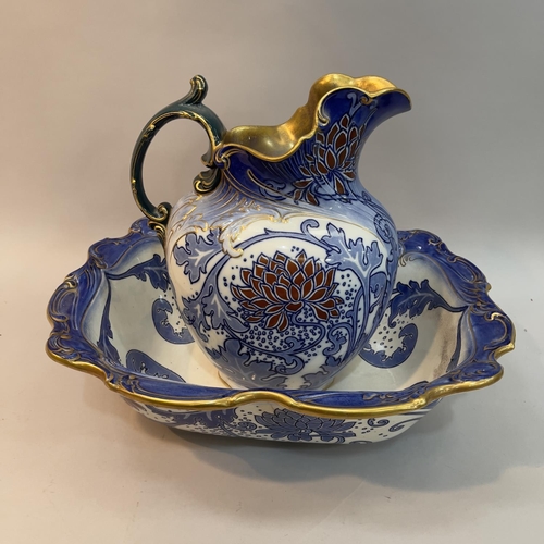 18 - A Doulton Burslem toilet jug and bowl of blue and white, fox red and gilt flowering foliage, jug 31c... 