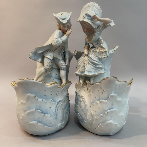 19 - A pair of late 19th century, continental pale blue bisque flower baskets surmounted with a beau and ... 