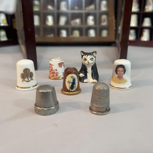 56 - A collection of china thimbles in six glazed cases