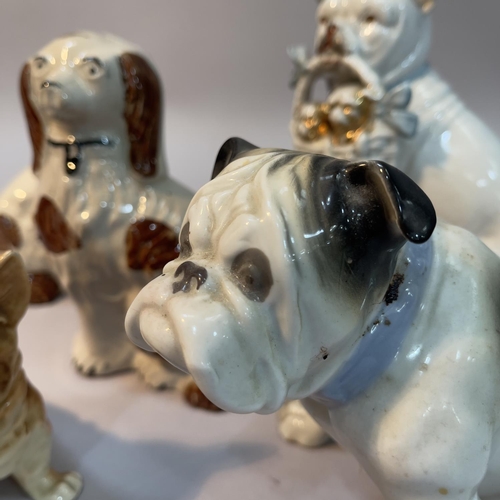 116 - A pair of Staffordshire spaniels 15cm high, a continental bulldog holding a basket of puppies, a Gra... 