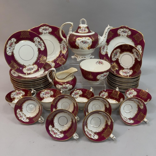 61 - An English china tea service printed and enamelled with flowers within a gilt cartouche and a puce g... 