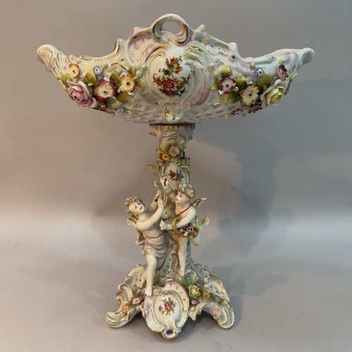 24 - An early 20th Century German and porcelain comport, the pierced basket encrusted with flowers, the p... 