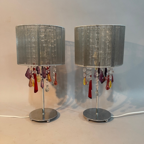 81 - A pair of white metal table lamps hung with pendant prismatic drops in clear and coloured glass, sil... 