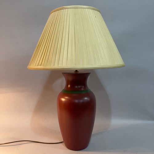 82 - A ceramic vase-shaped table lamp finished in dark terracotta with green band, cream pleated silk sha... 