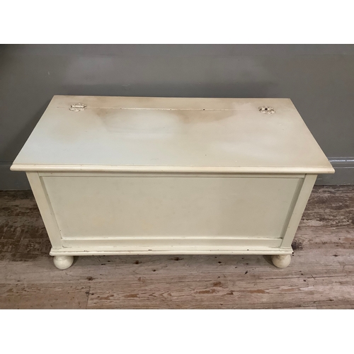 87 - A cream painted ottoman with hinged lid, 91cm wide