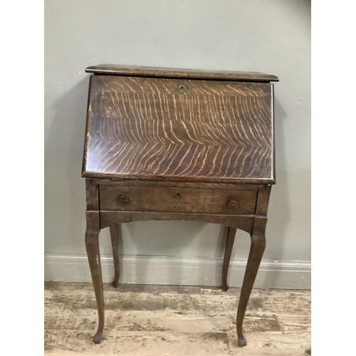 240 - An early twentieth century oak drop front bureau with fitted interior on cabriole legs