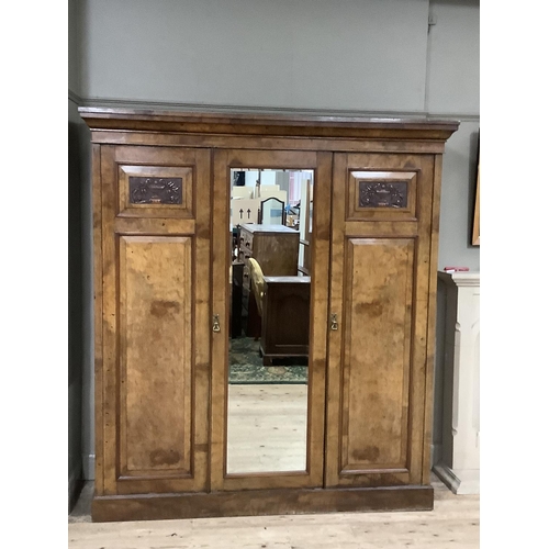 273 - A Victorian walnut triple wardrobe with carved cartouches, pediment top, central mirrored door, fitt... 