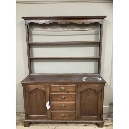 251 - An oak dresser with delft rack, pediment above three shelves, the base having four drawers to the ce... 