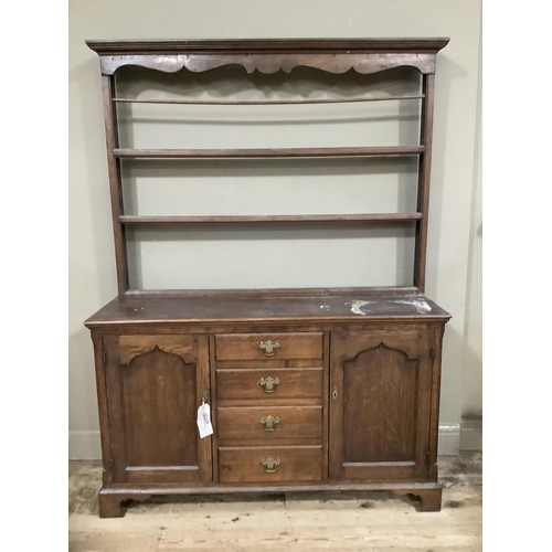 251 - An oak dresser with delft rack, pediment above three shelves, the base having four drawers to the ce... 