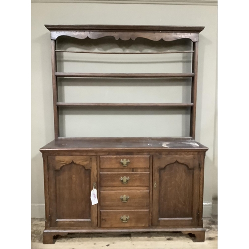 251 - An oak dresser with delft rack, pediment above three shelves, the base having four drawers to the ce... 