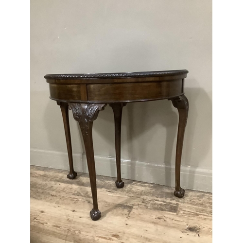 252 - An early twentieth century mahogany card table with gadroon rim having a pull out back leg with hidd... 