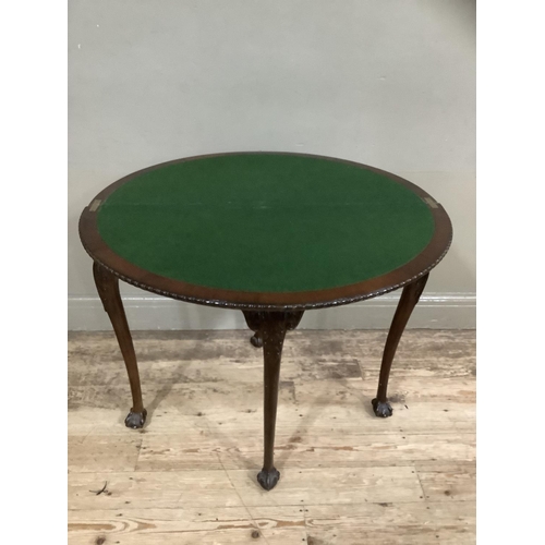 252 - An early twentieth century mahogany card table with gadroon rim having a pull out back leg with hidd... 