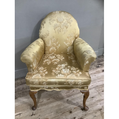 253 - A George III style walnut armchair on cabriole legs upholstered in gold fabric