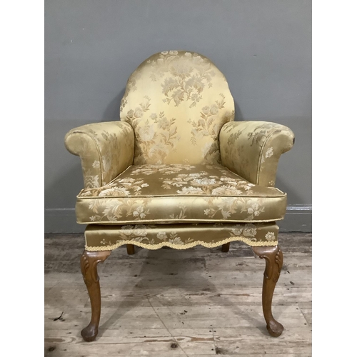 253 - A George III style walnut armchair on cabriole legs upholstered in gold fabric