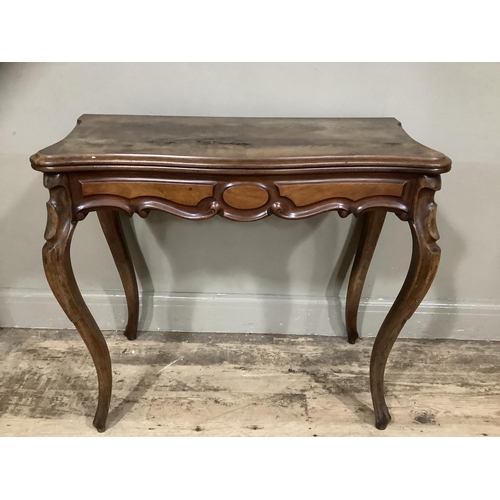 255 - A mahogany continental fold over tea table with carved apron above carved cabriole legs