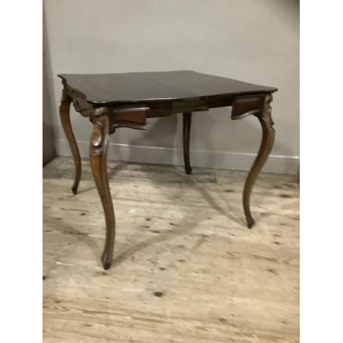 255 - A mahogany continental fold over tea table with carved apron above carved cabriole legs