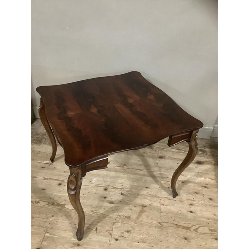 255 - A mahogany continental fold over tea table with carved apron above carved cabriole legs