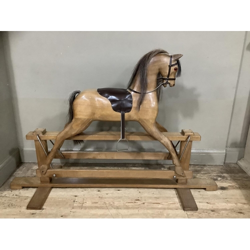 262 - A fruitwood carved rocking horse with leather reigns and saddle with horse hair mane and tail, 163cm... 